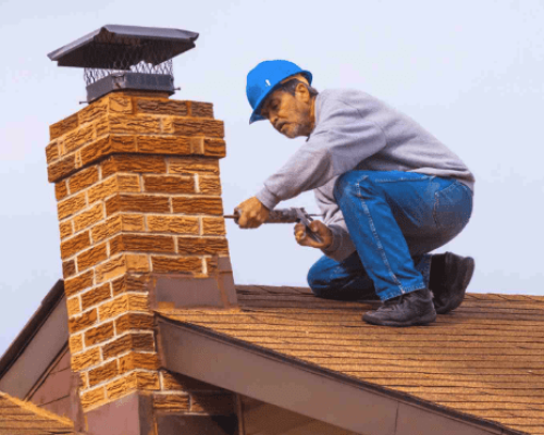 Chimney cleaning and repair technician working on Portland rooftop for chimney safety